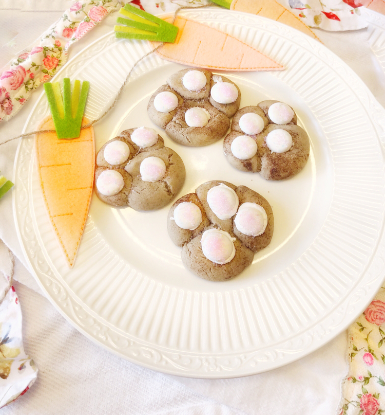 Cute bunny print snickerdoodle cookies on a white plate surrounded by a felt carrot banner