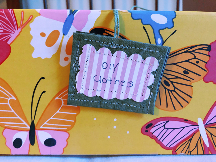 A colorful box with a diy organizing tag for organizing clothes