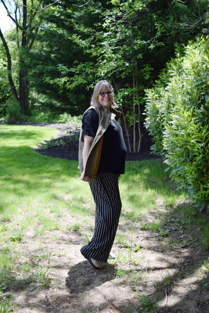 Woman wearing a pair of wide leg paints with black and white stripes.