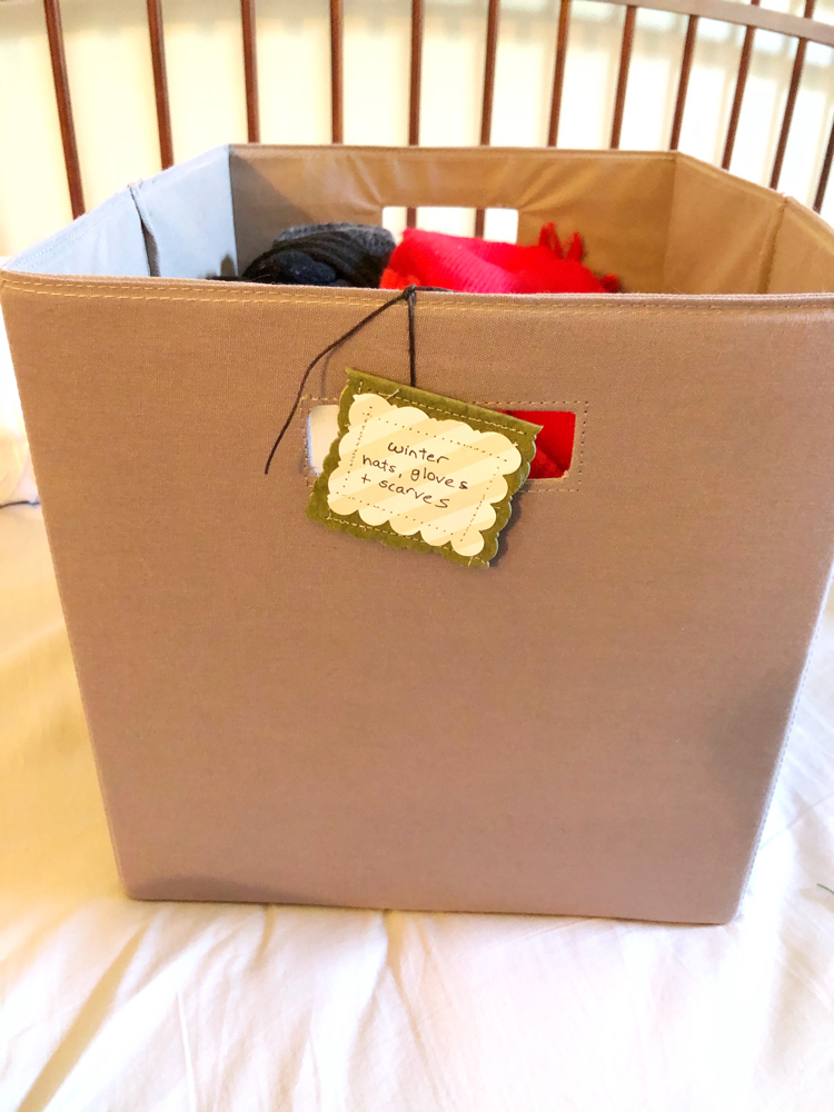 A storage bin of clothes with a DIY organizing tag