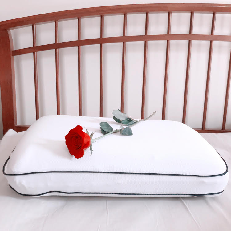 A farmhouse style bed with a memory foam cooling pillow  from Bed, Bath & Beyond with a rose on top.