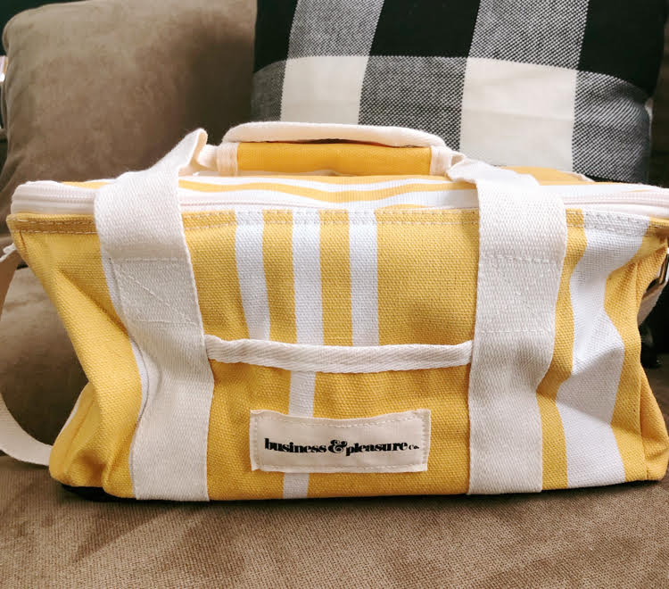 Yellow and white striped yellow cooler bag for carrying a picnic or cool drinks.