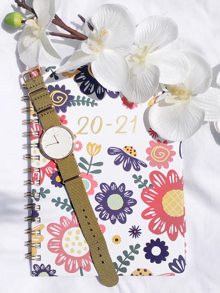 beautiful watch with a green nylon strap on a pretty datebook accented with colorful flowers