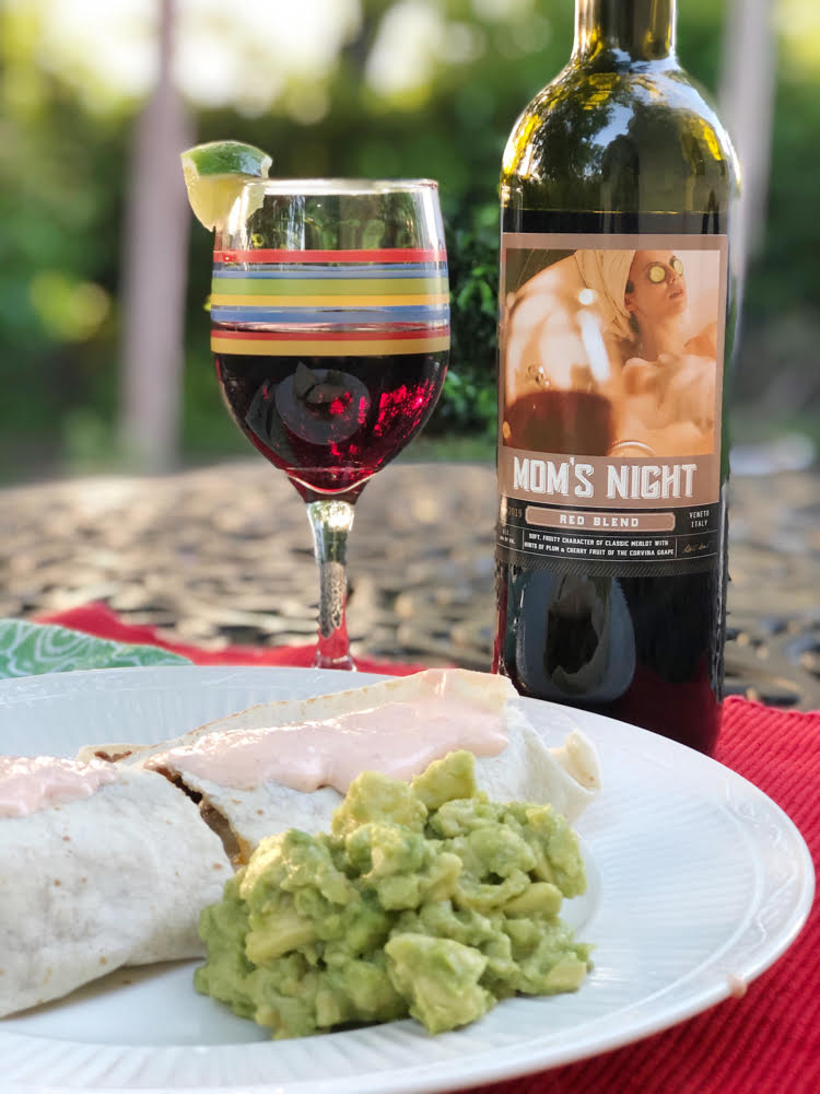 Mom's night red wine with a quesadilla and a side of guacamole on a wrought-iron table on an outdoor patio