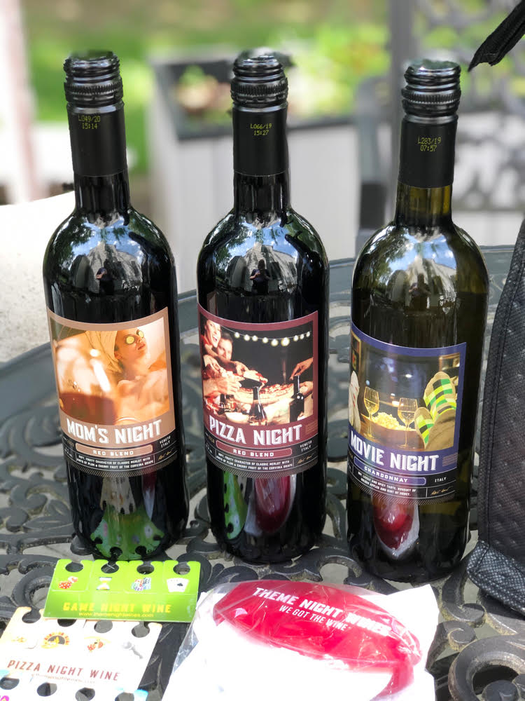 Bottles of Mom's Night, Pizza Night and Movie Night Wines from Theme Night Wines on a wrought iron patio table.