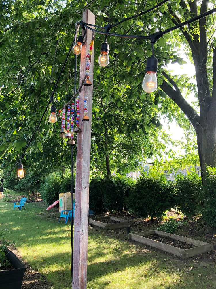 string lights hung from planter posts on a patio