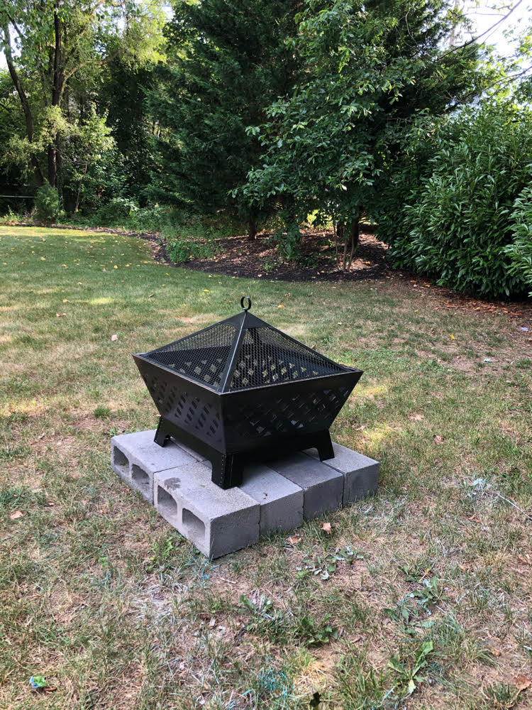 a beautiful Landmann metal fire pit on a base of concrete blocks