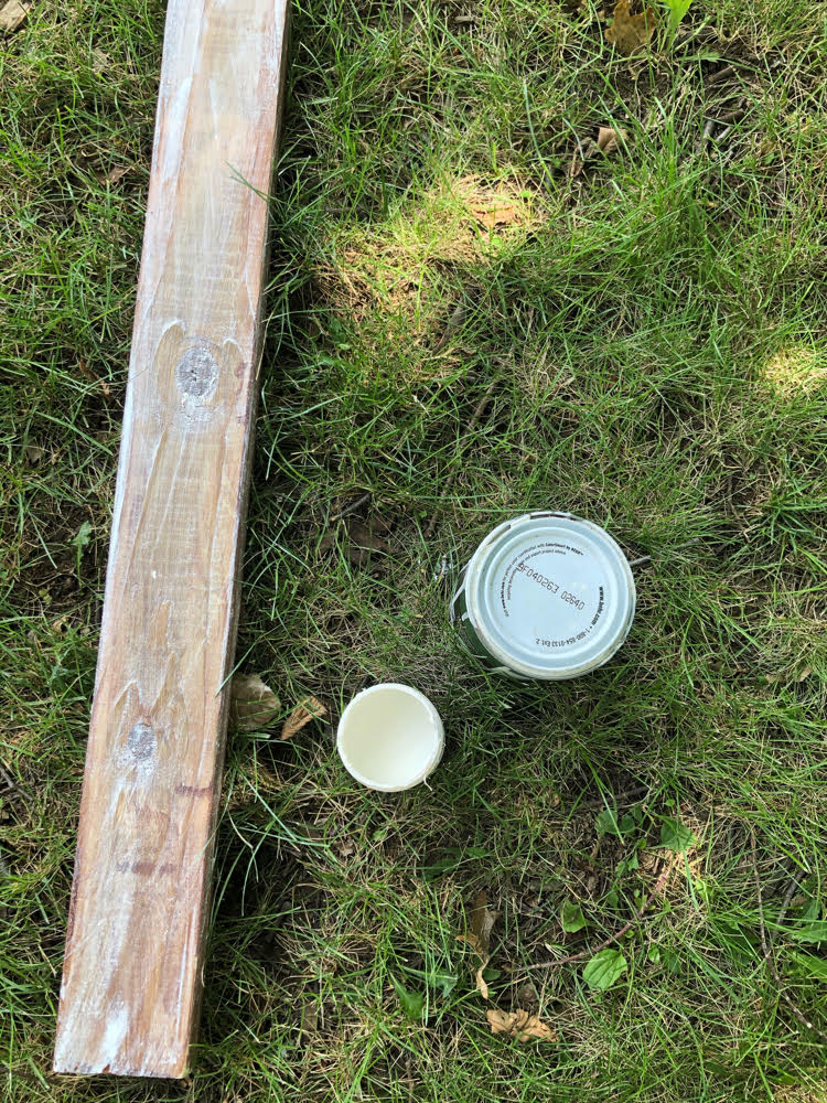 A stained and whitewashed 2 x 4 wood post for hanging string lights