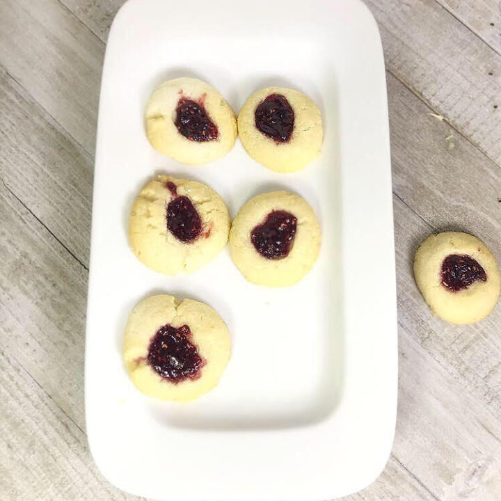 raspberry thumbprint cookies on a rectangular plate