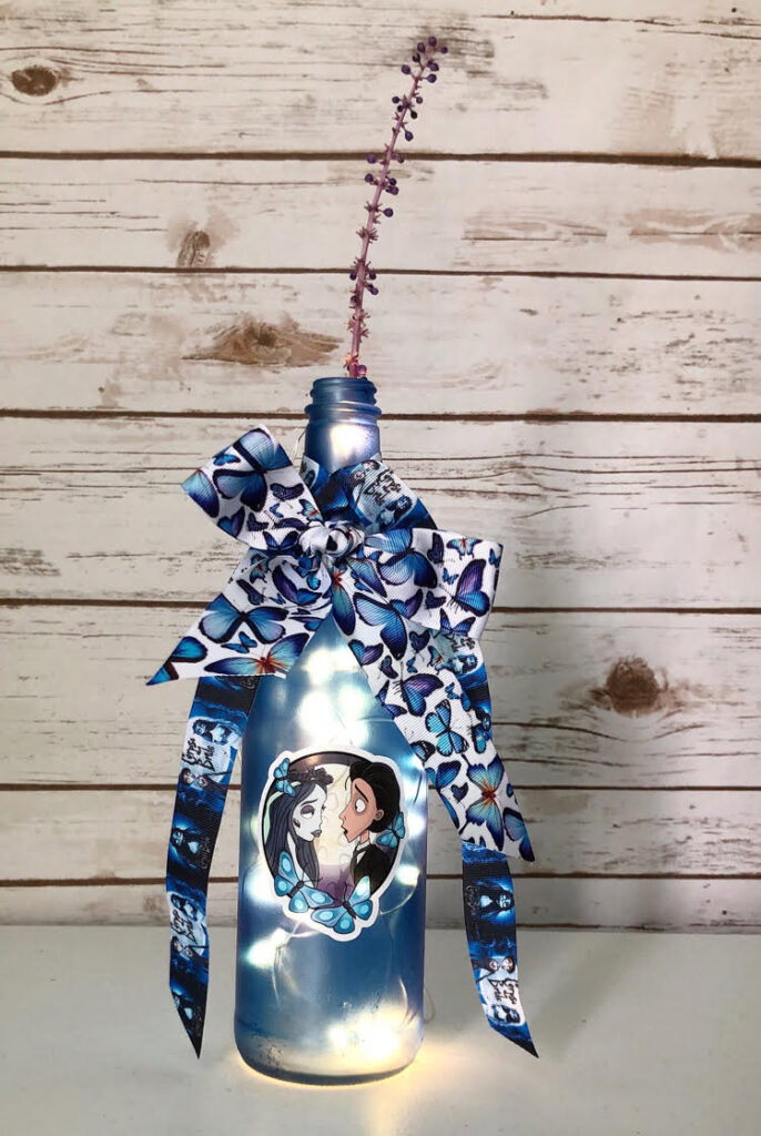 DIY decorated blue wine bottle in a Corpse Bride theme