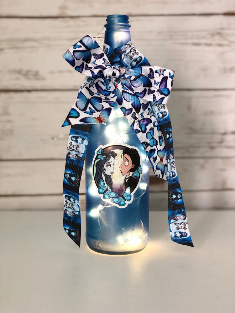 a hand-decorated Corpse Bride wine bottle with a Corpse Bride sticker and ribbons
