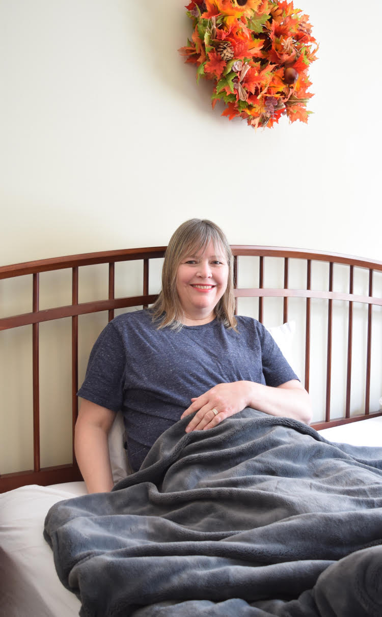 woman under a weighted plush blanket in a fall bedroom