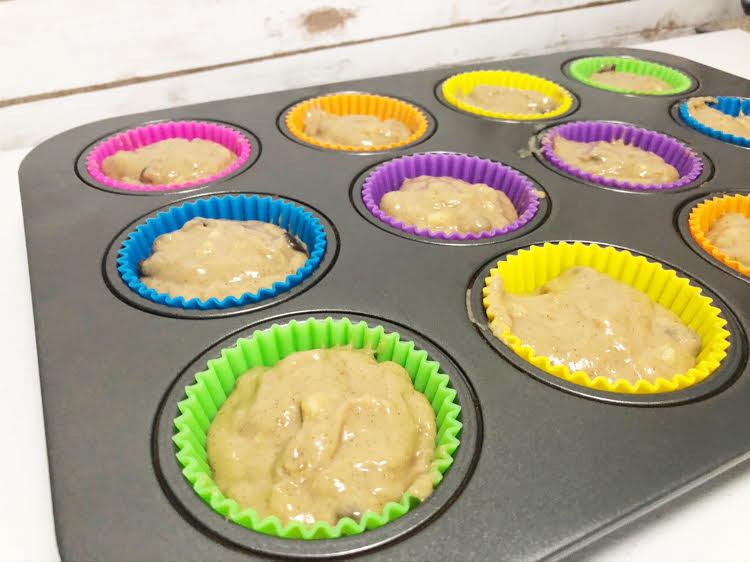 muffin batter in colorful silicone cupcake liners in a muffin tin