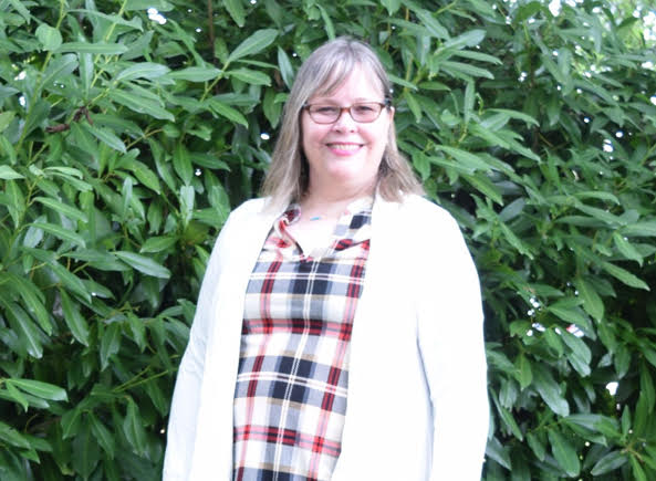 woman wearing a plaid top and white cardigan sweater