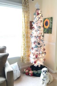 artificial white Christmas tree with a Shih Tzu sitting in front