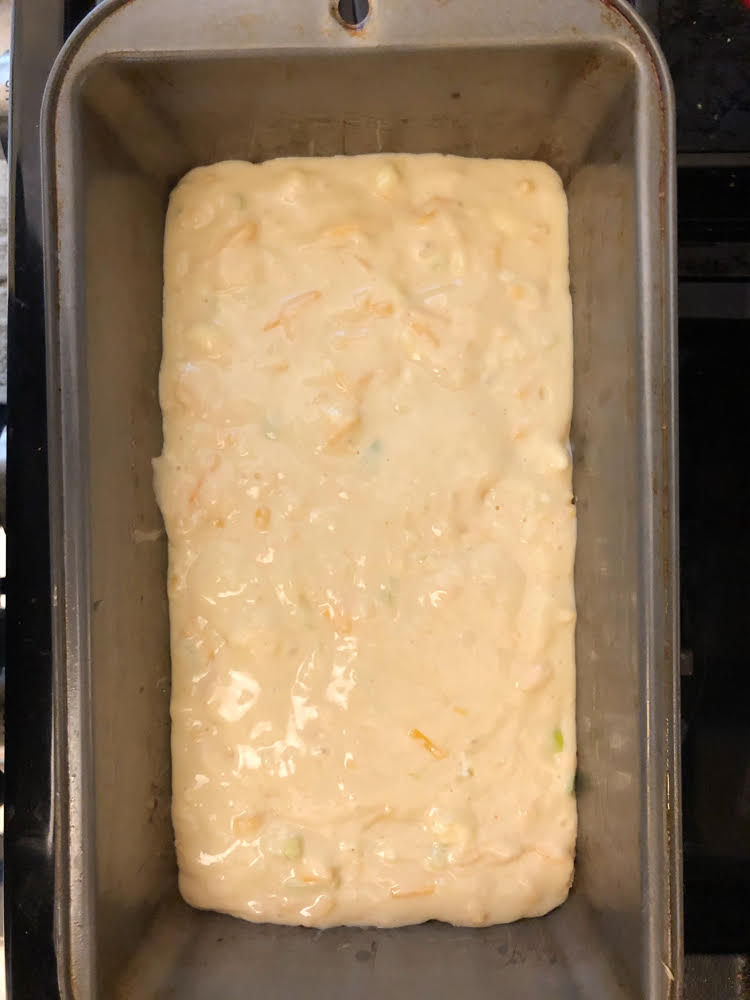 cheddar green onion bread batter in a loaf pan