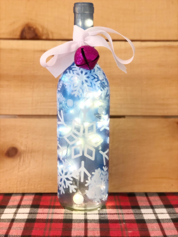 a beautiful DIY lighted wine bottle decorated with snowflakes