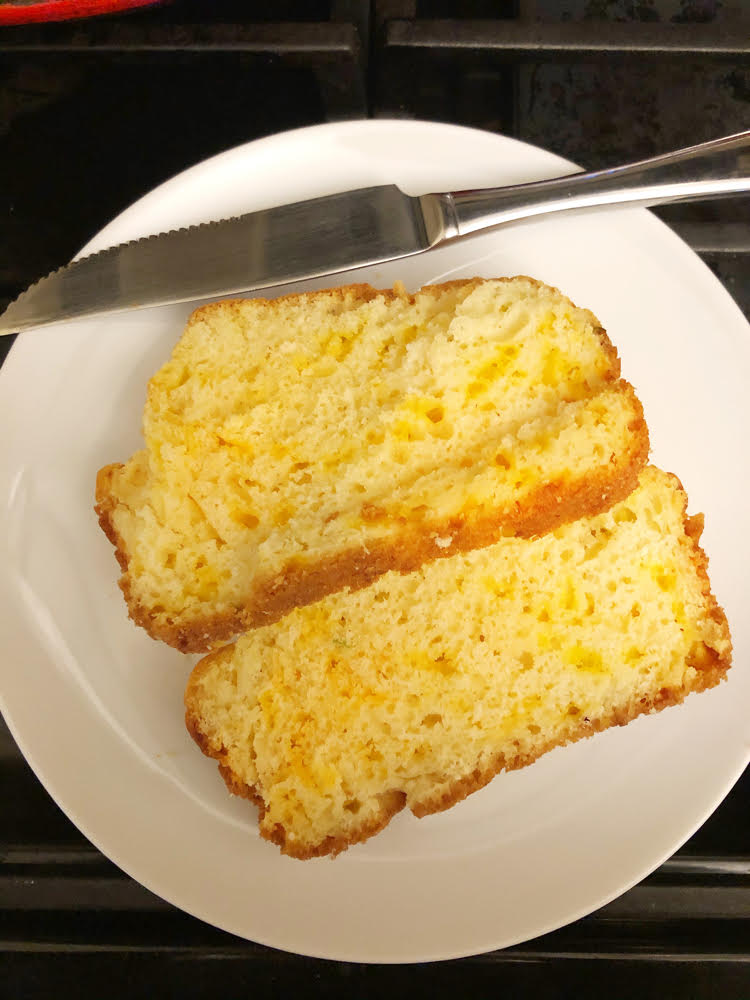 two slices of homemade cheddar cheese and green onion quick bread