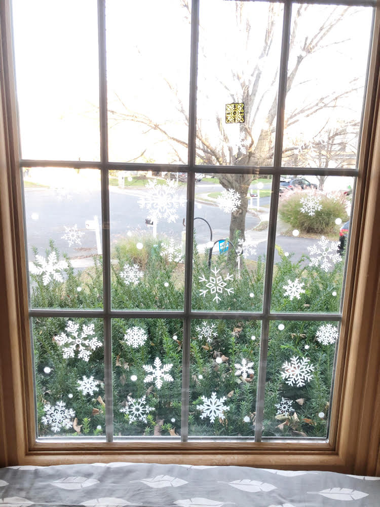 white vinyl snowflakes in a bay window for Christmas