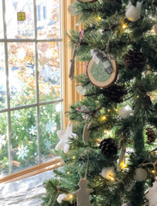rustic faux christmas tree by a window with snowflake decals
