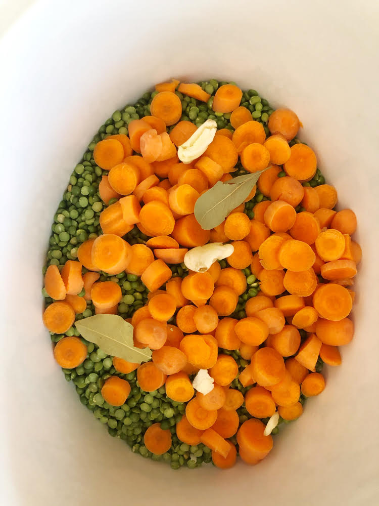 split pea soup ingredients - peas, carrots, garlic and a bay leaves