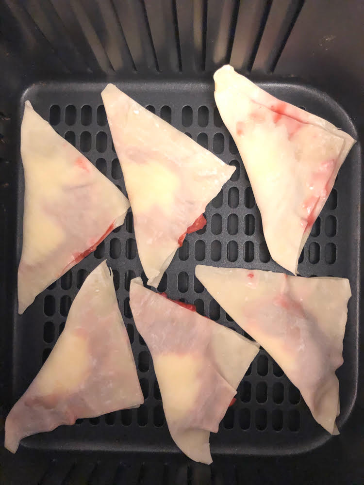 6 strawberry and cream cheese in the basket of an air fryer