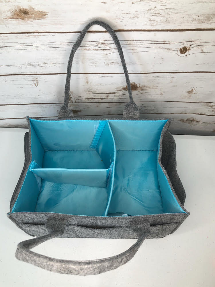 The felt Mimmo Caddy by Mollie Ollie has removable dividers to make compartments within the caddy.