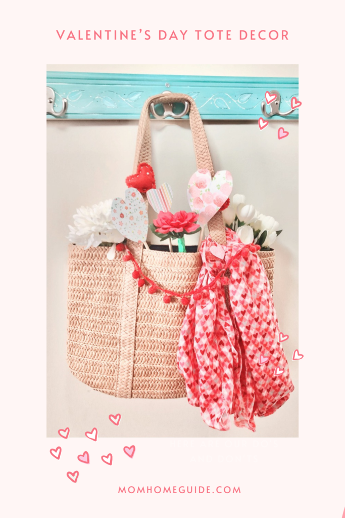 a straw tote filled with paper and felt hearts and decorated with a hearts scarf and pom pom fringe