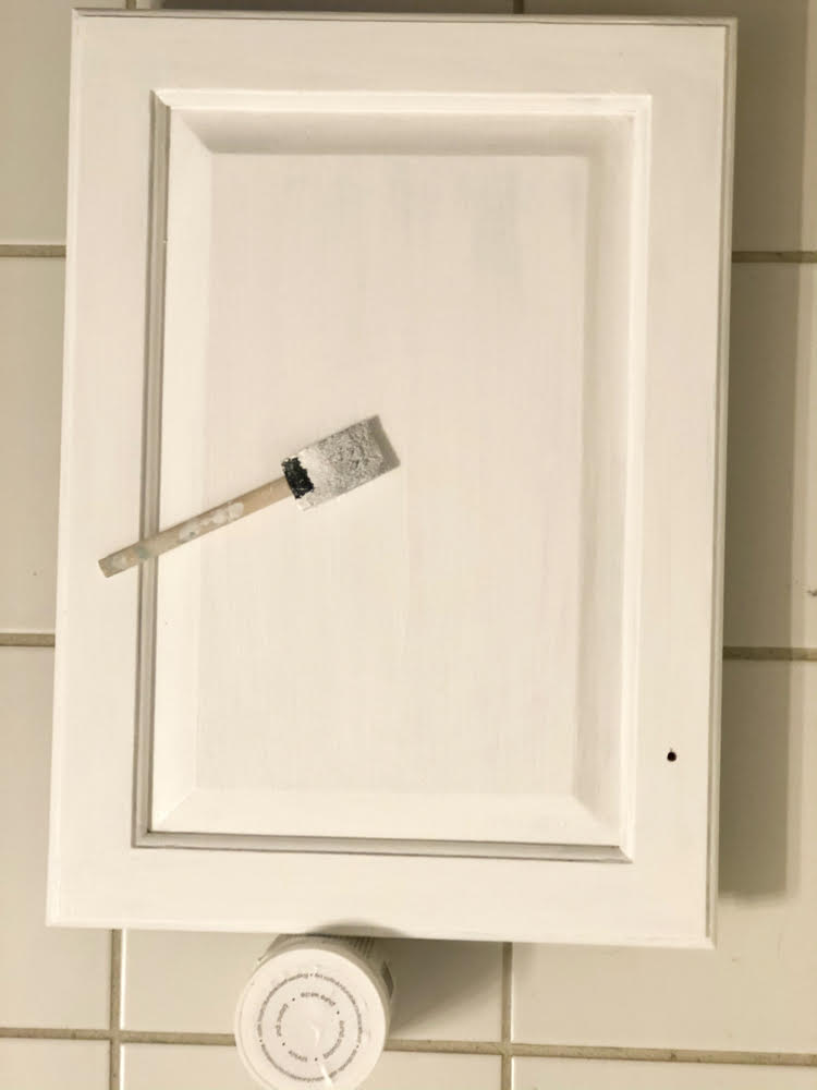 using a foam paint brush to paint a bathroom cabinet