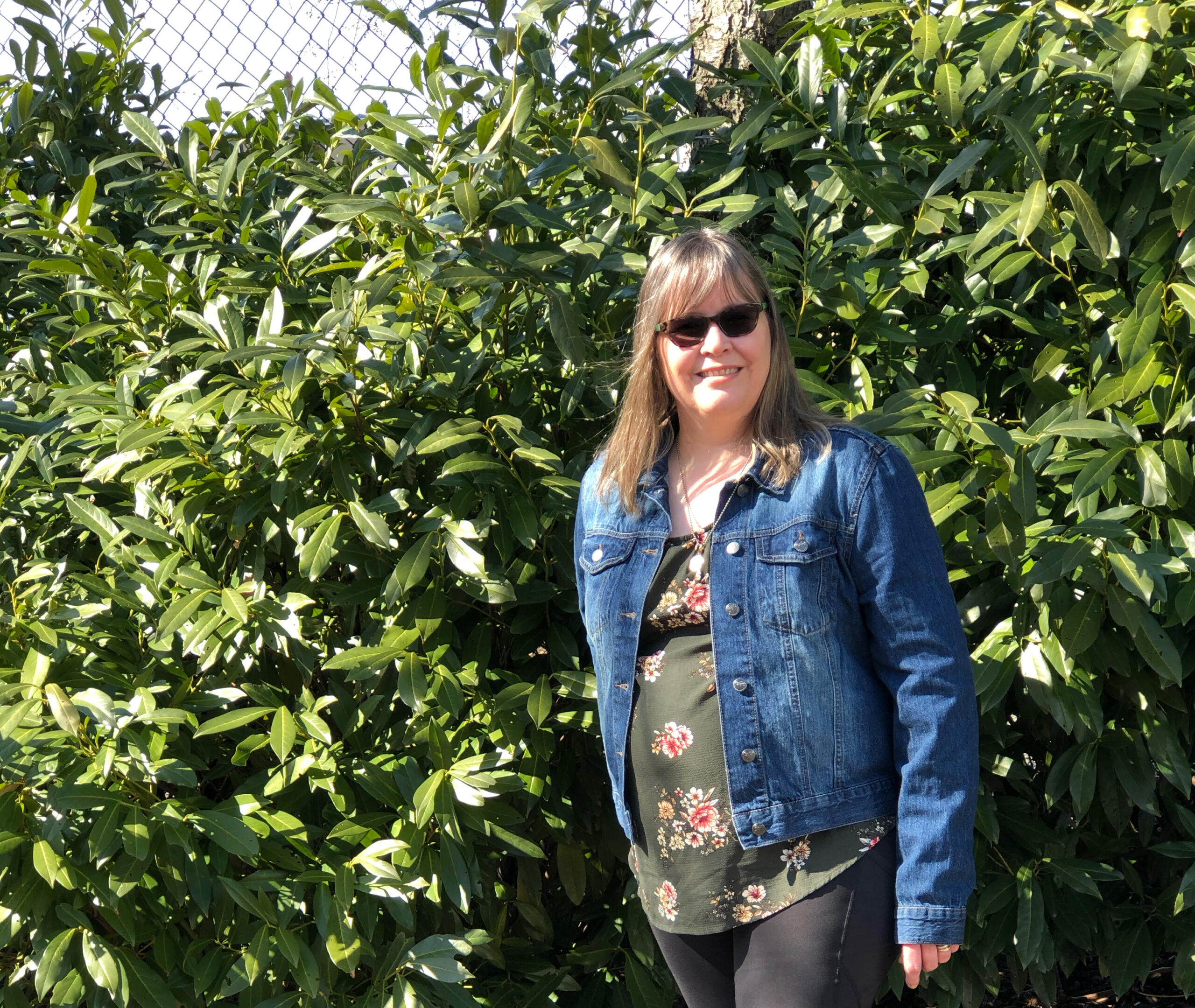 Spring outfit: floral top, denim jacket and black tights