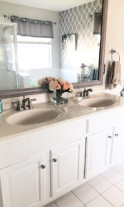 bathroom with a custom MirrorChic bathroom mirror frame and bathroom cabinets painted white