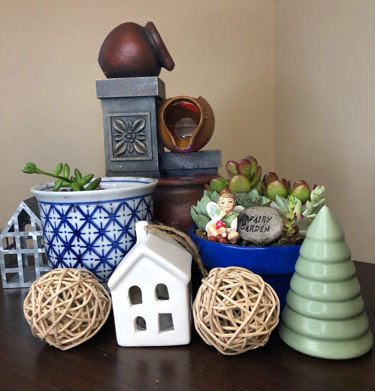 a fairy garden with succulents and zen fountain