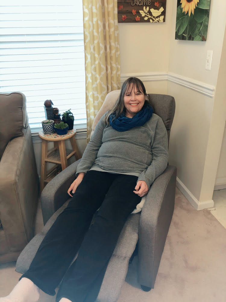 woman relaxing in a gray living room recliner chair