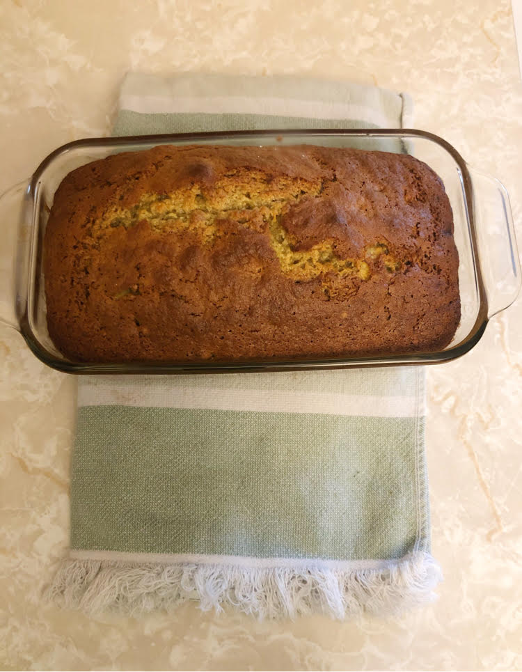 healthy banana bread loaf made with applesauce instead of bread in a glass pyrex baking dish