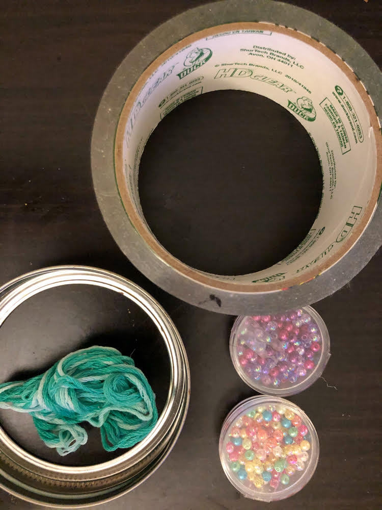 supplies for making an easy and beautiful DIY suncatcher with a mason jar ring, tape and beads