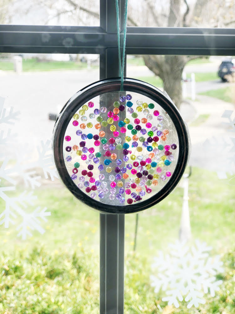 a pretty DIY suncatcher made with a mason jar ring, beads and iridescent beads