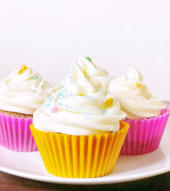 carrot cupcakes with cream cheese icing in colorful silicone liners