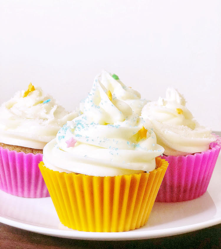 homemade carrot cupcakes with cream cheese icing in colorful silicone cupcake wrappers
