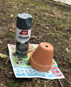 gray spray paint can and a terra cotta pot