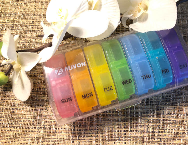 colorful daily pill organizer with separate daily pill containers with day and night pill sections