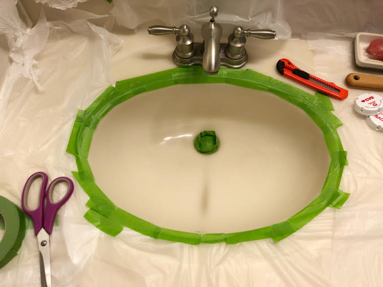 A sink taped off to be refinished with a crisp white Ekopel enamel