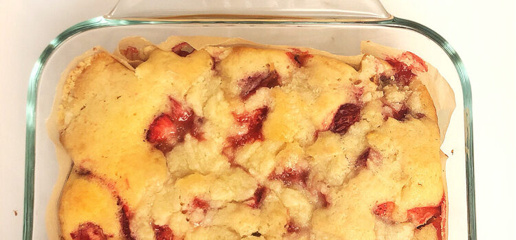 fresh strawberry coffee cake and a ceramic container filled with strawberries