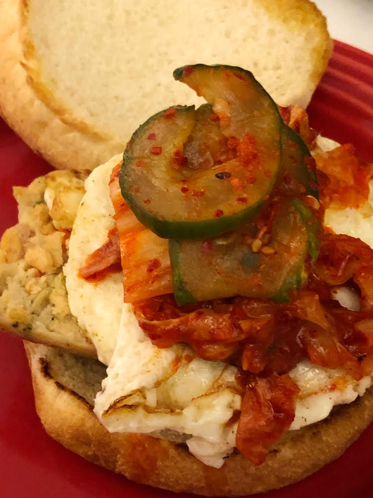 a healthy breakfast sandwich with a Big Brat Veggie Link, a fried egg and kimchi