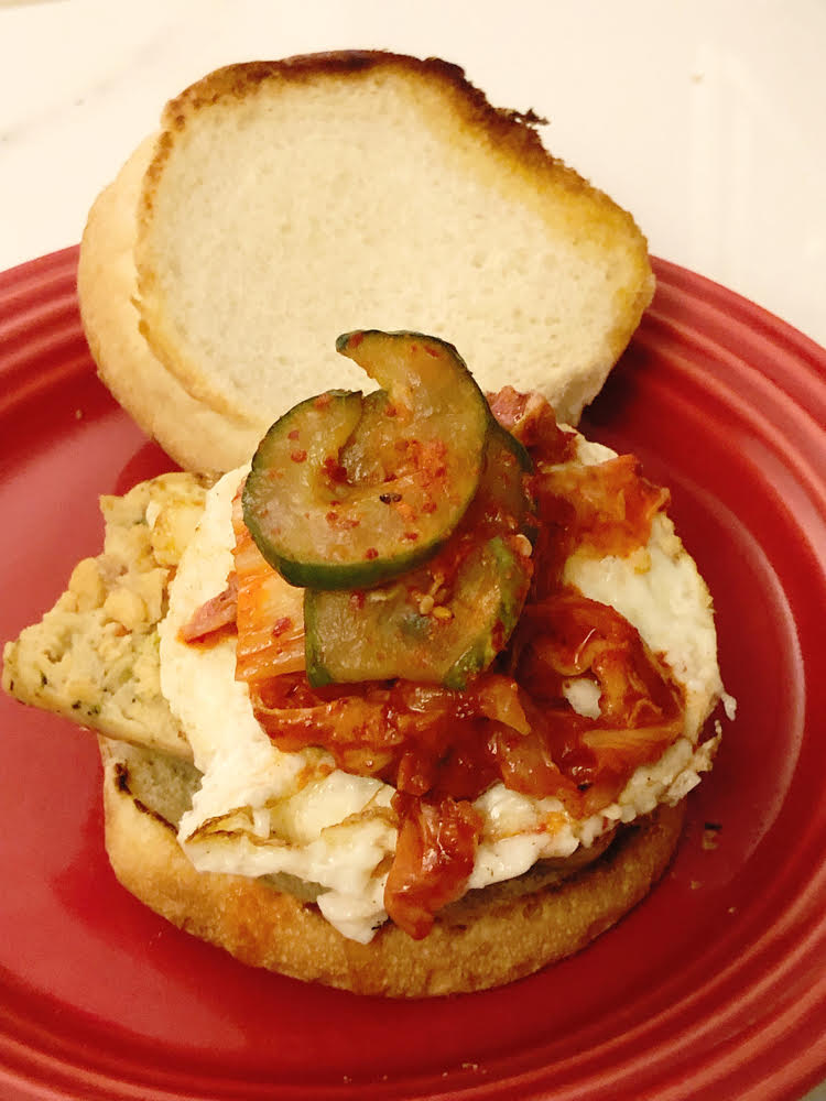 veggie brat sandwich with a fried egg and kimchi