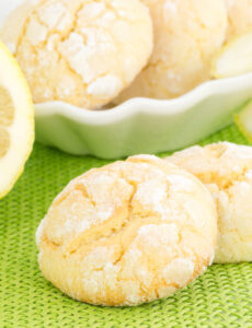 lemon cookies on a plate with a slice of lemon