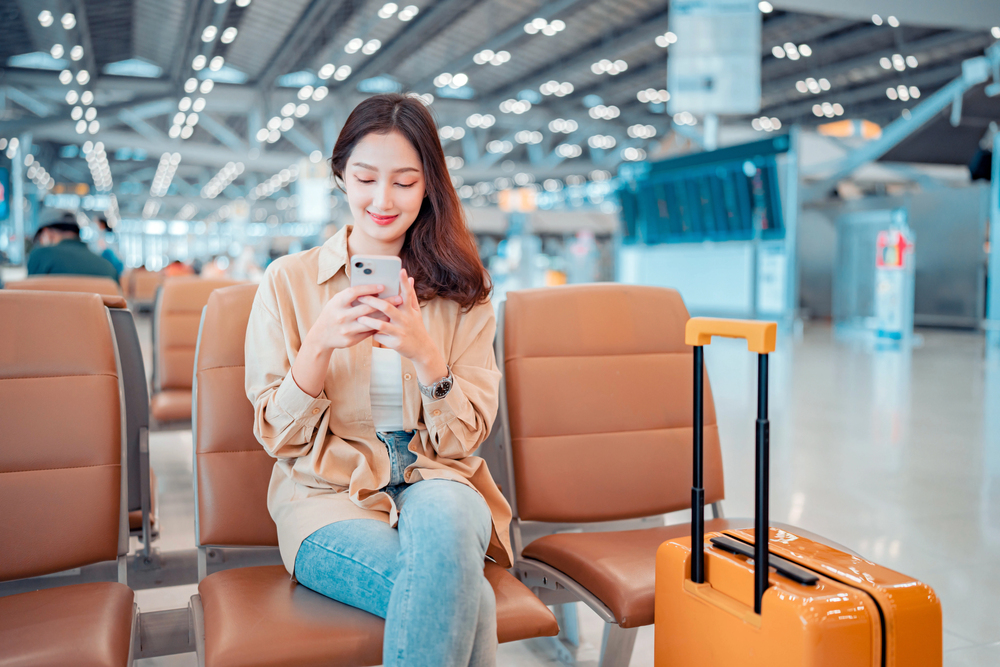 happy woman waiting for flight at airport