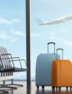 suitcases at airport with airplane taking off in the distance