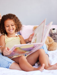 a mom reading to her daughter at bed time