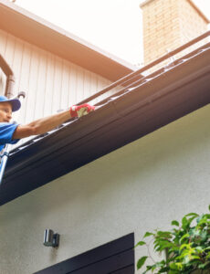 person on ladder, working on roof