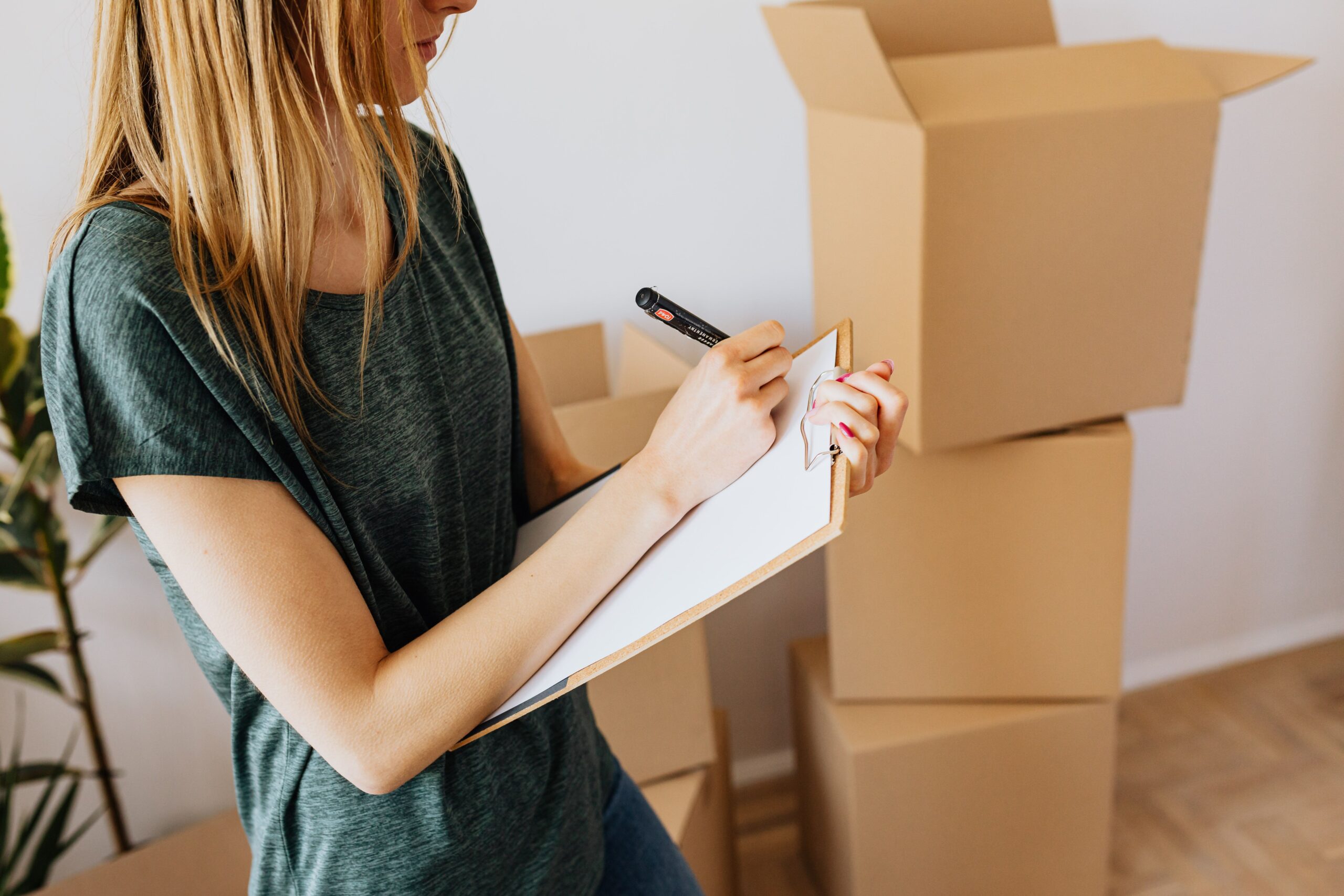 a woman writing a moving checklist